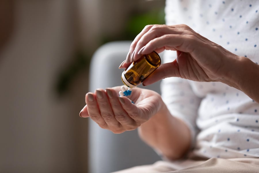 Tabletten auf die Hand geben aus Flasche
