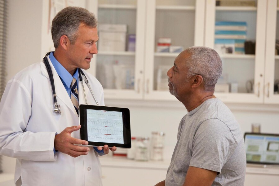 Arzt erklärt Patienten etwas auf einem Tablett