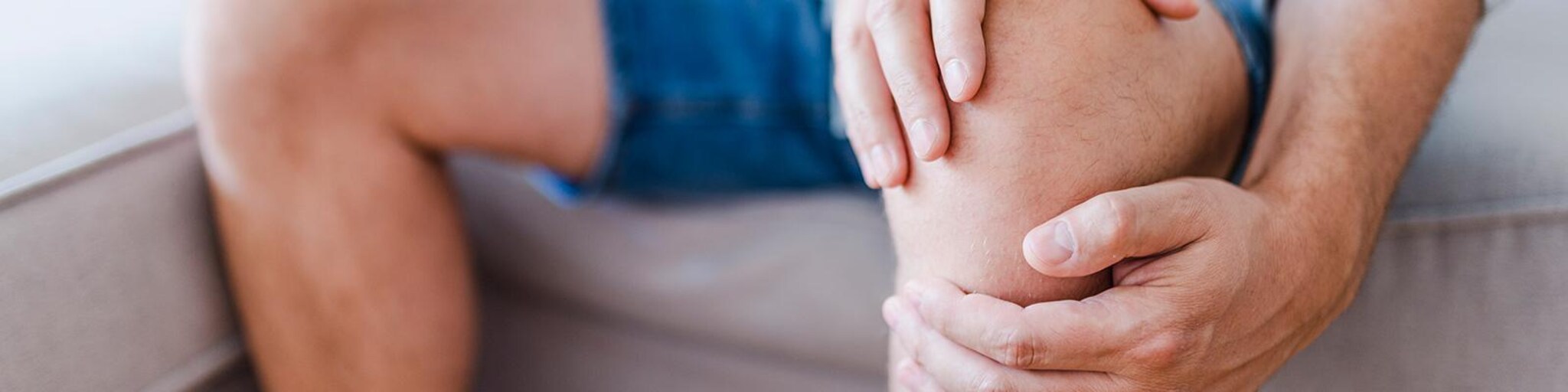 Mann greift um sein Knie