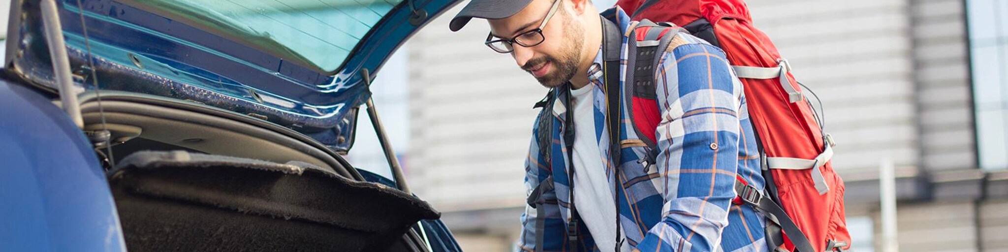 Mann packt Tasche ins Auto