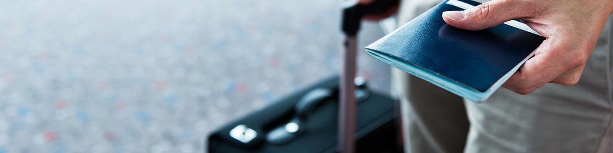 Mann zieht koffer und zeigt reisepass