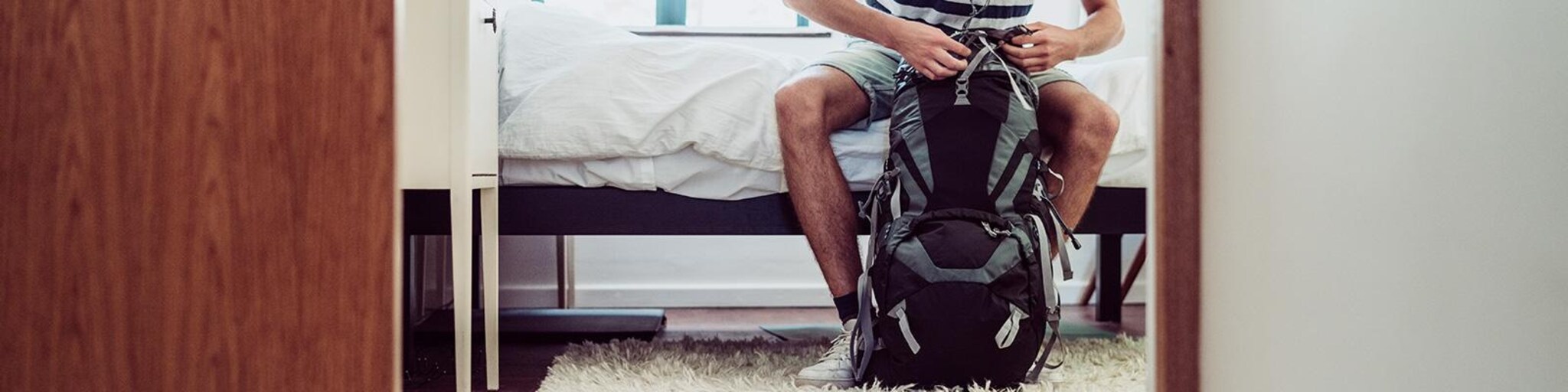 Junger Mann packt rucksack