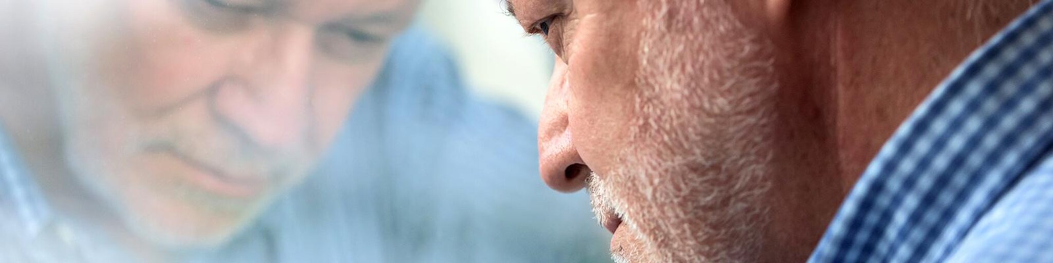 Depressiver Mann vor Glasscheibe